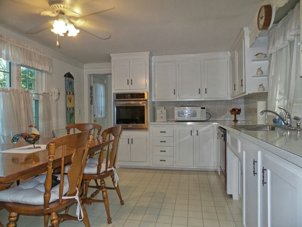 33 James Road Reading, MA 01867 - Photo 10 of 27 a kitchen with stainless steel appliances a sink a stove a refrigerator cabinets and dining table