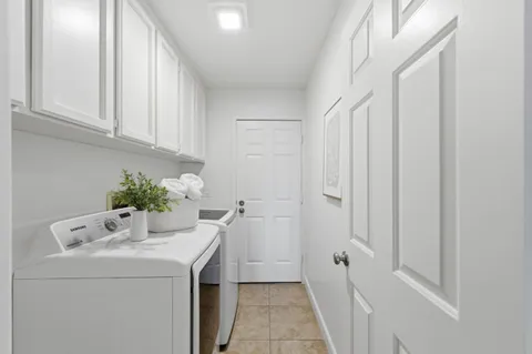 a utility room with cabinets washer and dryer