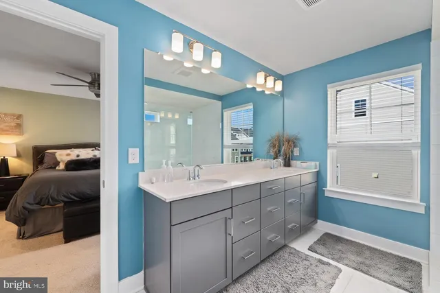 a en suite bathroom with a double vanity sink and a mirror