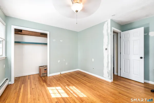 a view of empty room with wooden floor