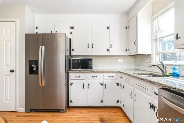 a kitchen with stainless steel appliances granite countertop a refrigerator sink and cabinets