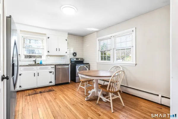 a kitchen with a table chairs a sink dishwasher window and cabinets