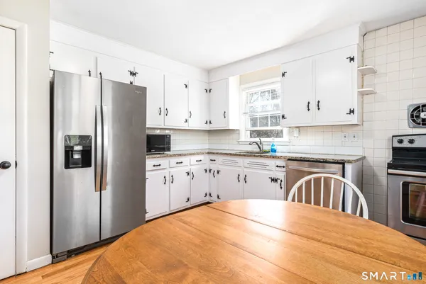 a kitchen with granite countertop a refrigerator stove top oven and sink