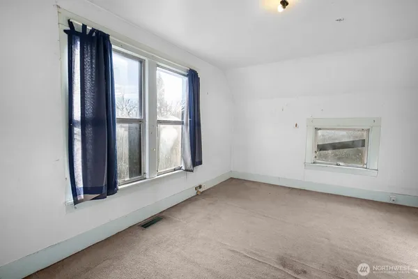 an empty room with windows and closet