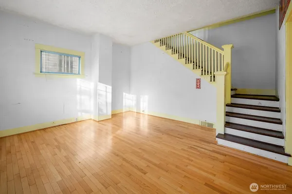 a view of a room with wooden floor and white walls