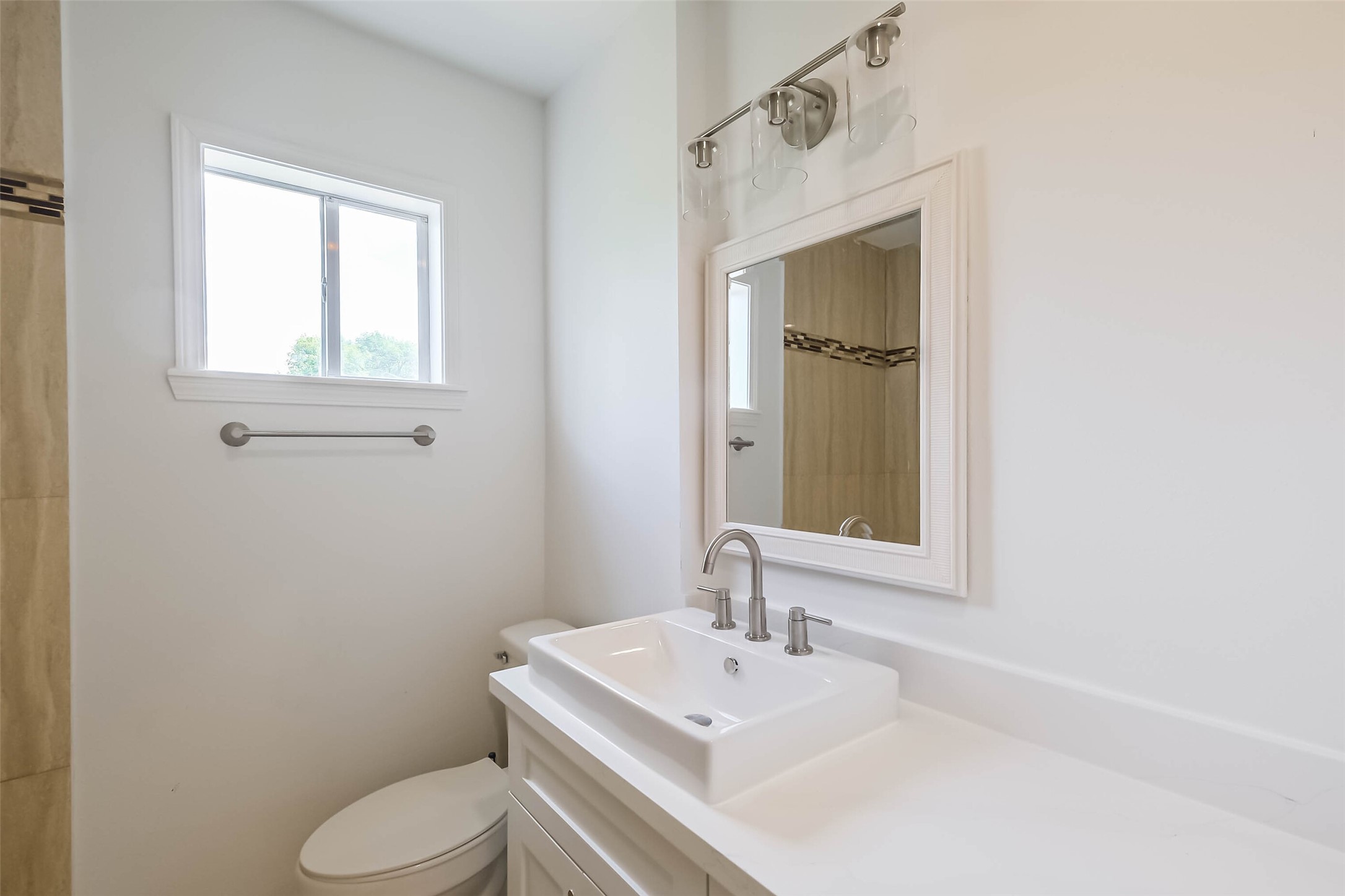 7543 Greenstone Street Houston, TX 77087 - Photo 12 of 24 a bathroom with a toilet sink a mirror and window