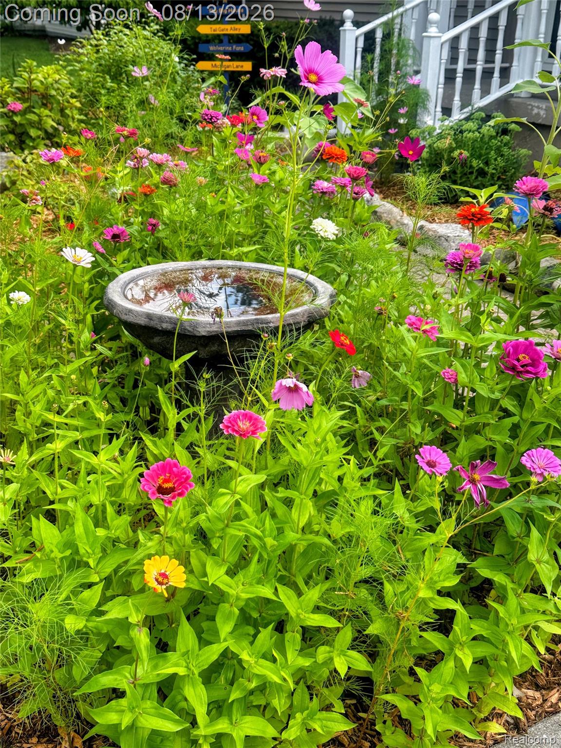 10361 Coldwater Road Flushing, MI 48433 - Photo 34 of 37 Landscaped garden bed featuring a variety of colorful blooms and a stone bird bath