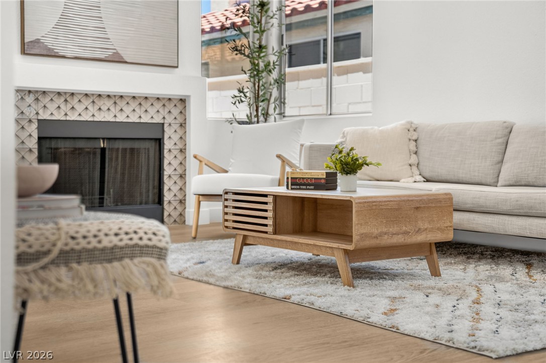 2681 Rungsted Street Las Vegas, NV 89142 - Photo 8 of 33 Warm wood flooring extends across this inviting living room, complemented by a cozy fireplace with stylish tile surround.