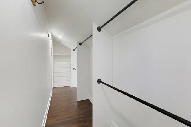 a view of hallway with stairs and wooden floor