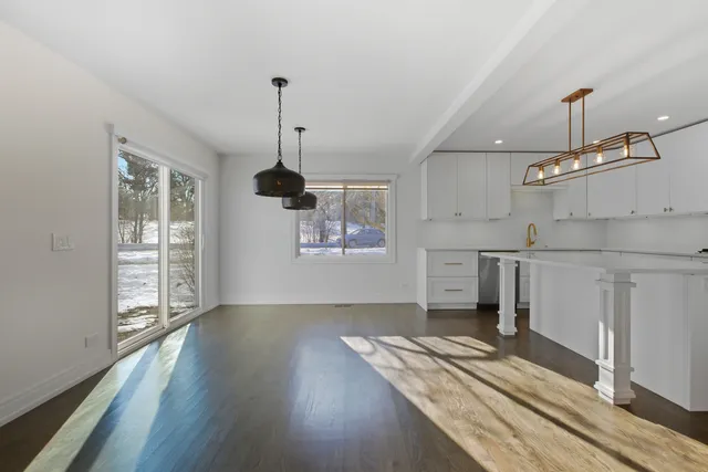 a view of a kitchen with wooden floor electronic appliances and furniture