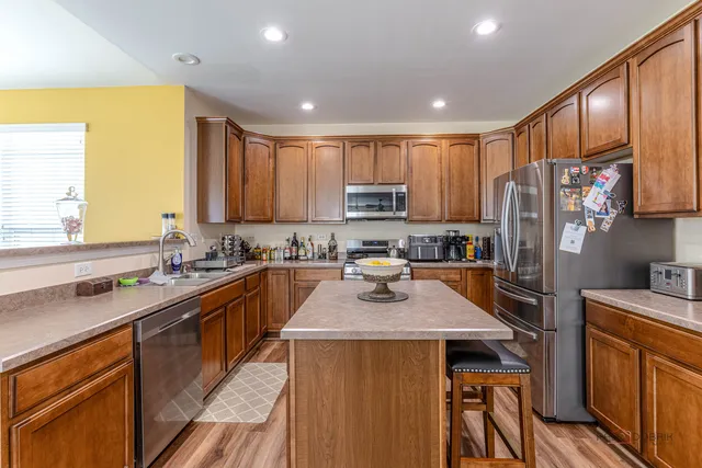 a kitchen with stainless steel appliances granite countertop a refrigerator stove microwave and sink