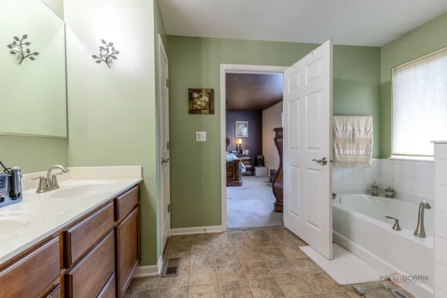 a bathroom with a tub sink and mirror