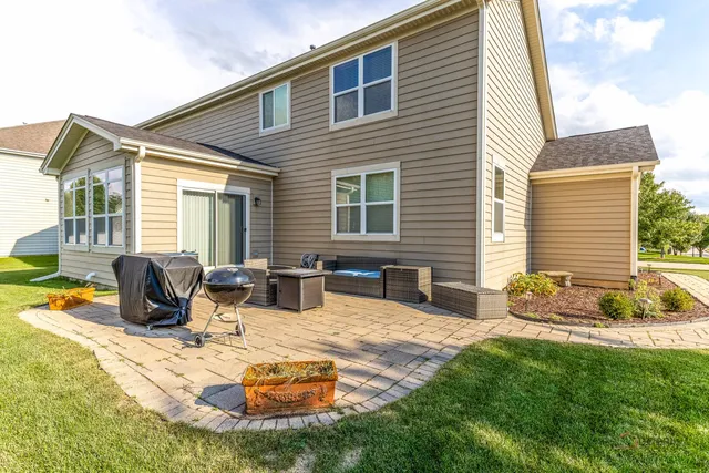 a view of a house with backyard and sitting area