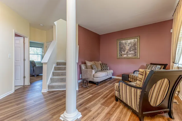 a living room with furniture and a wooden floor
