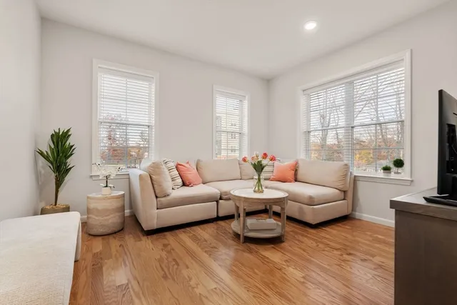 a living room with furniture flat screen tv and window
