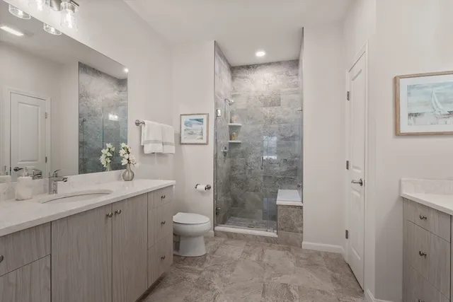a bathroom with a double vanity sink toilet and shower