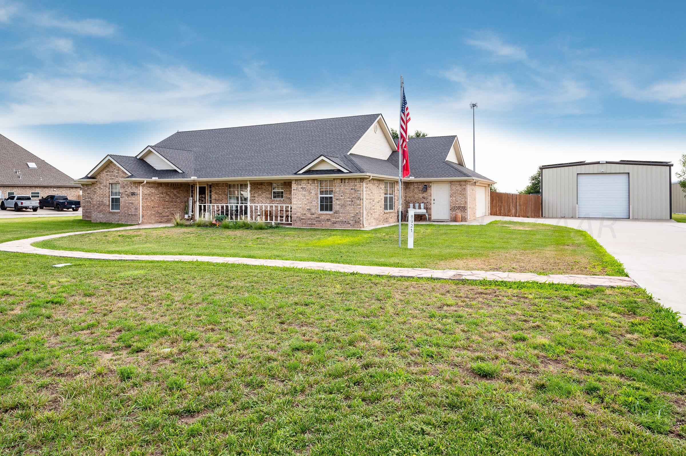 a view of a house with a big yard and large trees