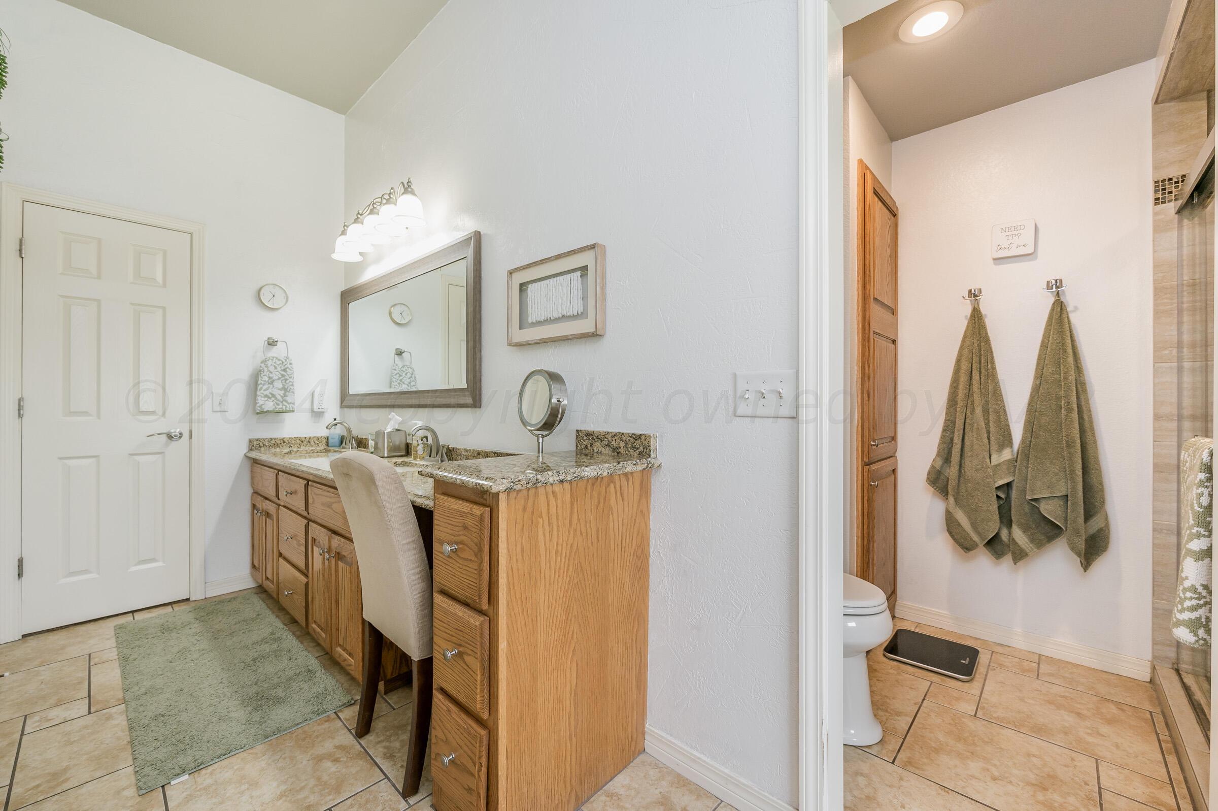 8921 Greyhawk Road Amarillo, TX 79119 - Photo 14 of 56 a bathroom with a double vanity sink and a mirror