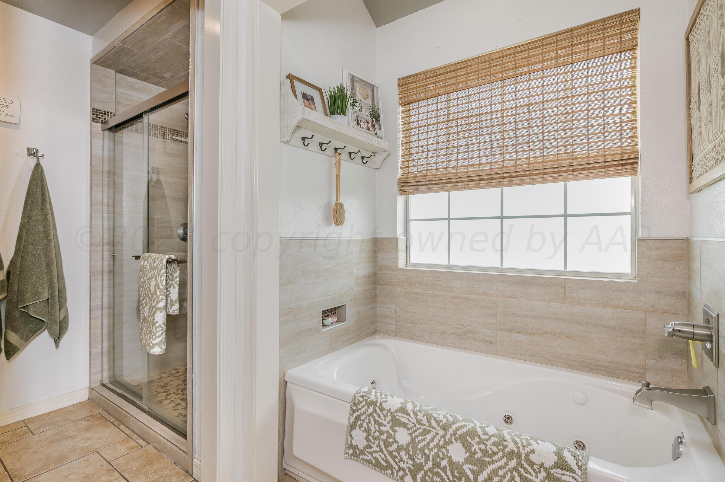 8921 Greyhawk Road Amarillo, TX 79119 - Photo 15 of 56 a bathroom with a tub a sink and a shower