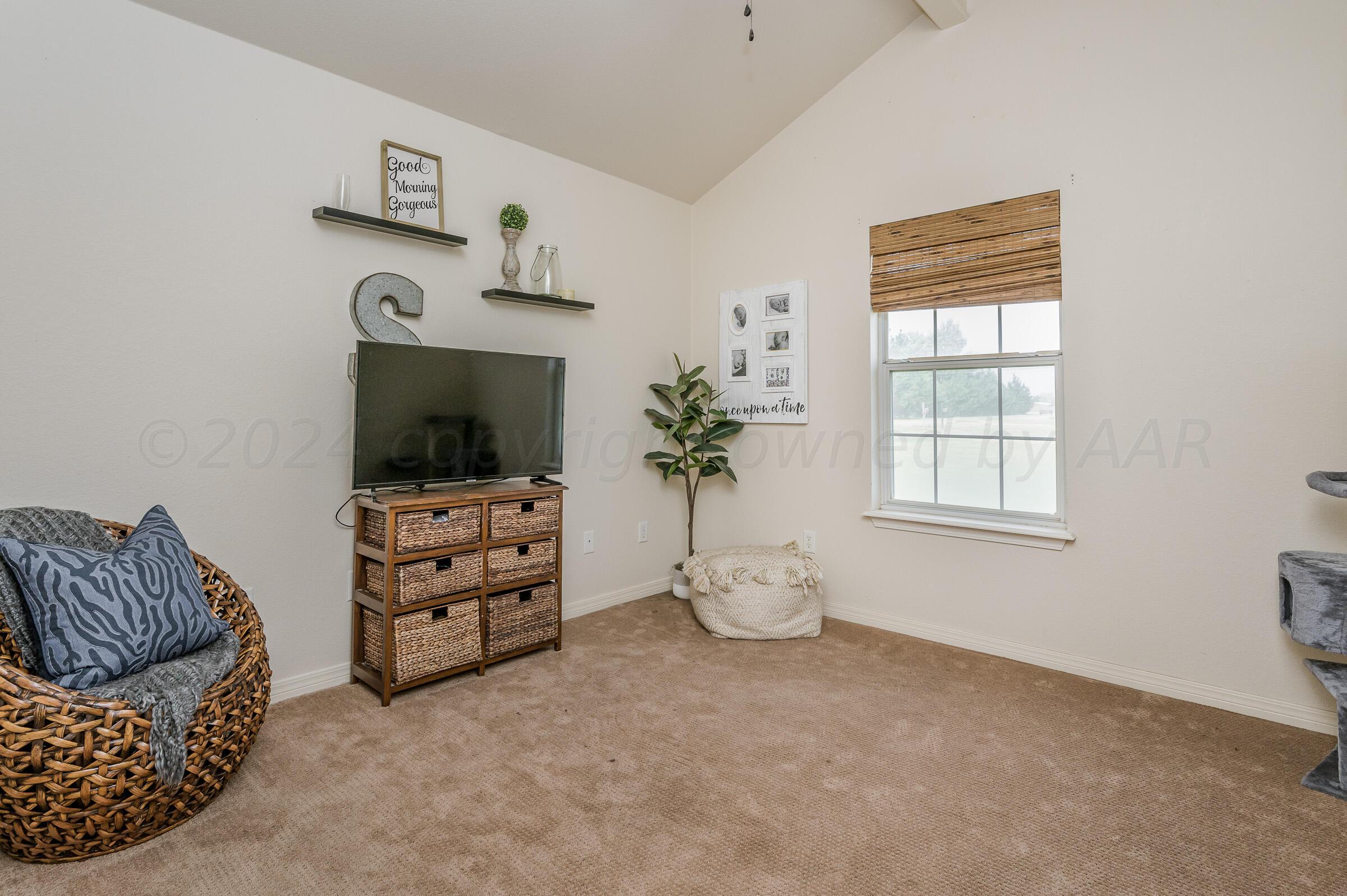 8921 Greyhawk Road Amarillo, TX 79119 - Photo 18 of 56 a living room with furniture and a flat screen tv