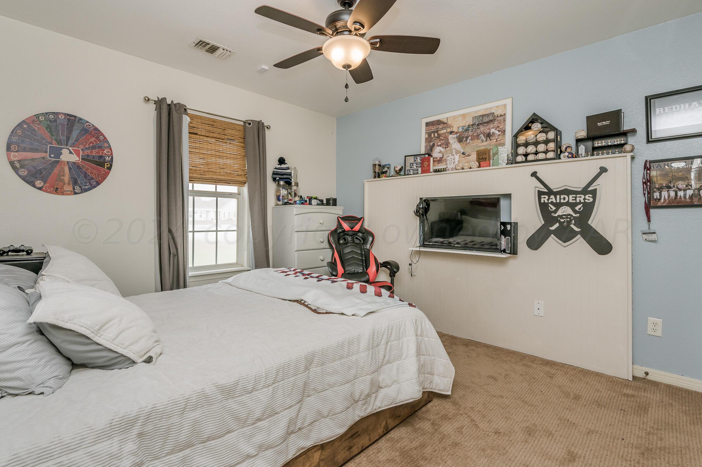 8921 Greyhawk Road Amarillo, TX 79119 - Photo 20 of 56 a bedroom with a bed and a chandelier
