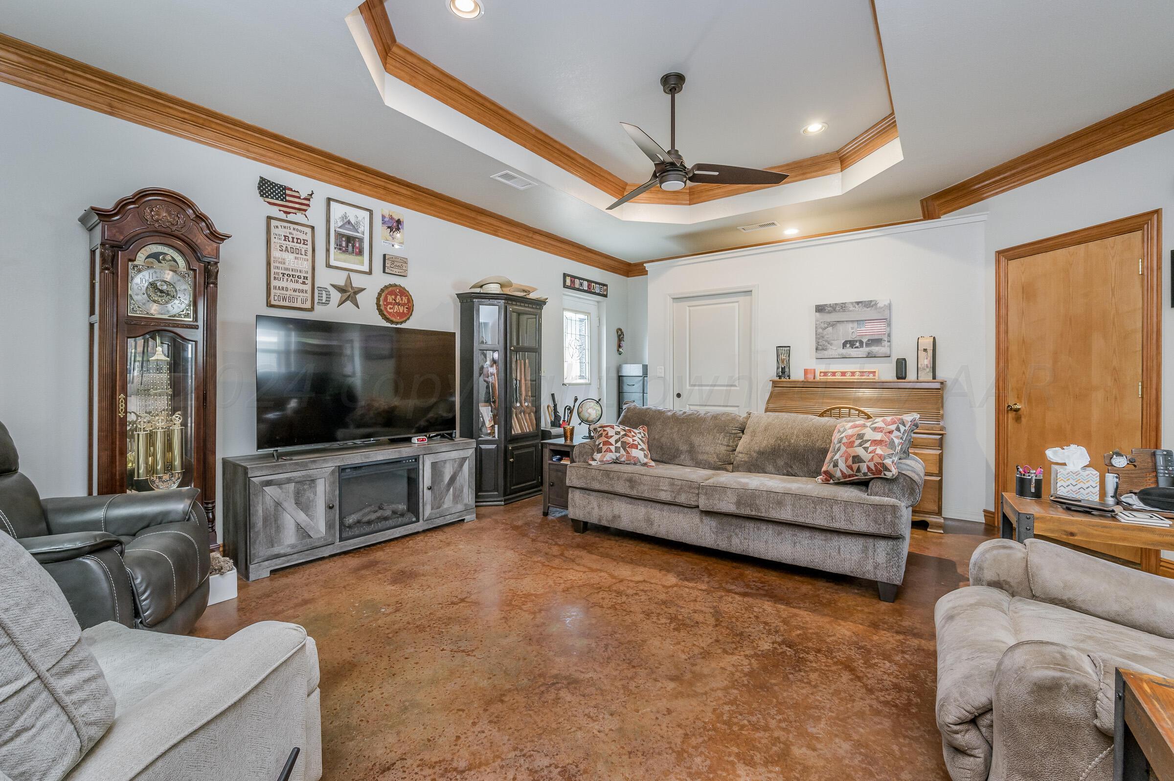 8921 Greyhawk Road Amarillo, TX 79119 - Photo 30 of 56 a living room with furniture and a flat screen tv
