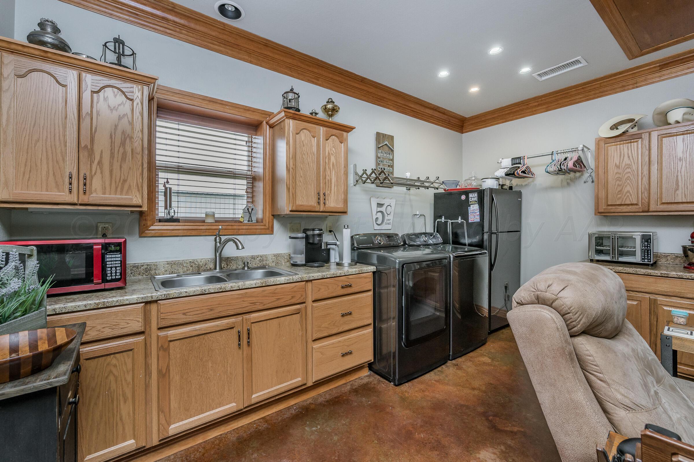 8921 Greyhawk Road Amarillo, TX 79119 - Photo 32 of 56 a kitchen with refrigerator cabinets and furniture