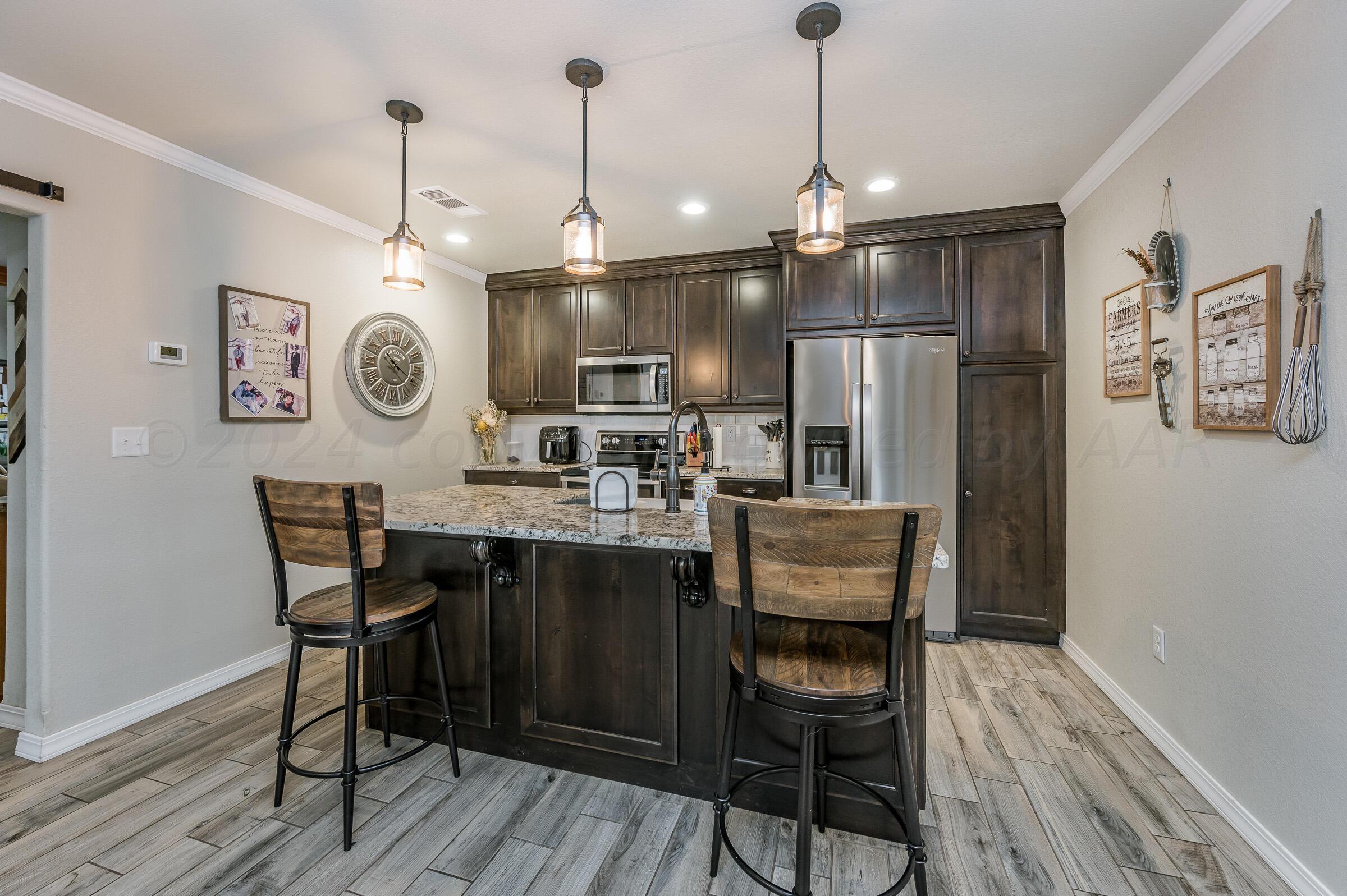 8921 Greyhawk Road Amarillo, TX 79119 - Photo 34 of 56 a dining room with wooden floor and a chandelier
