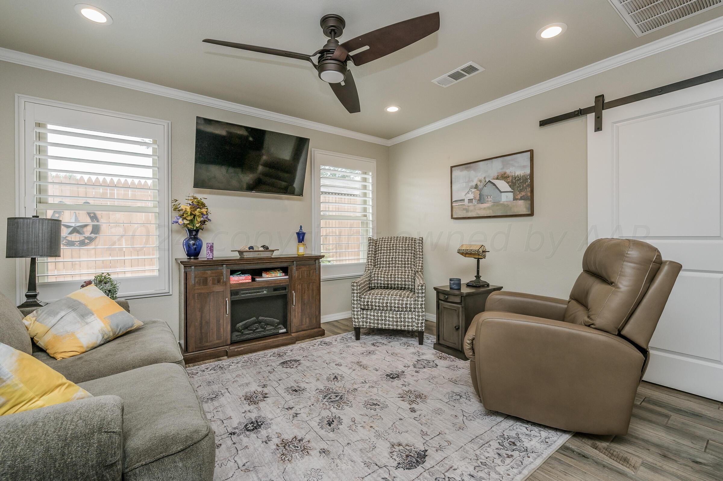 8921 Greyhawk Road Amarillo, TX 79119 - Photo 36 of 56 a living room with furniture and a flat screen tv