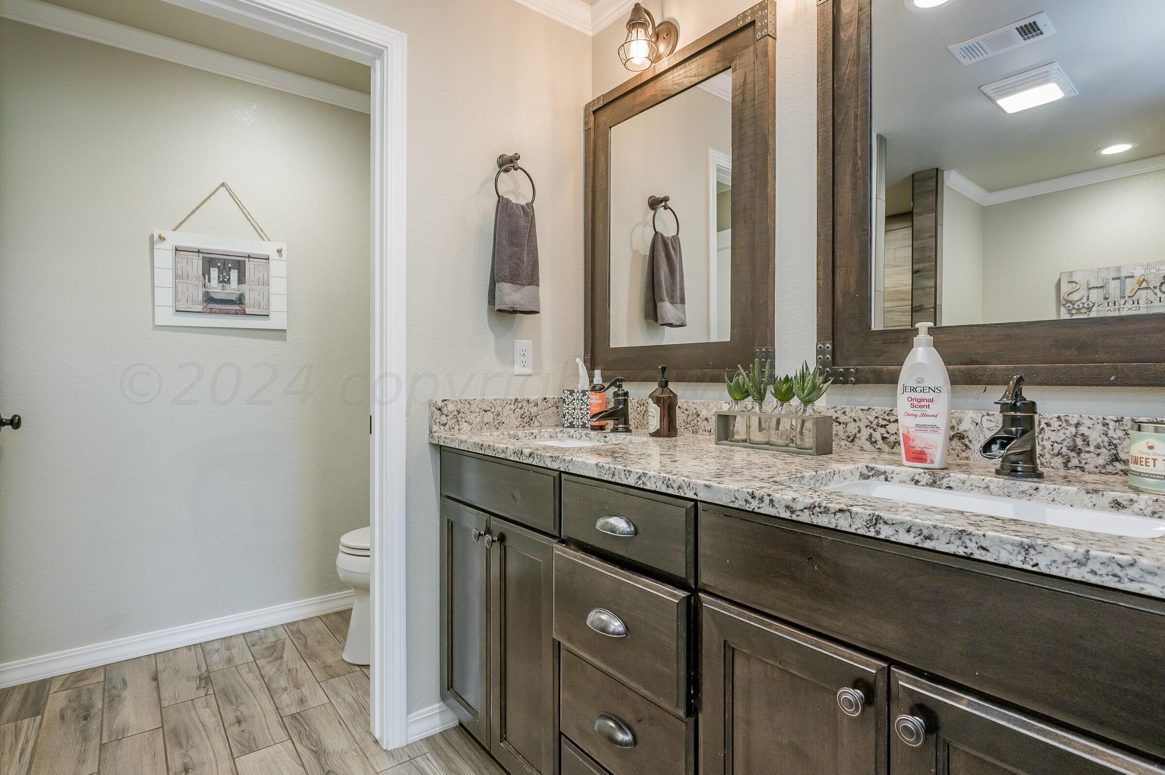 8921 Greyhawk Road Amarillo, TX 79119 - Photo 40 of 56 a bathroom with a granite countertop sink and a mirror