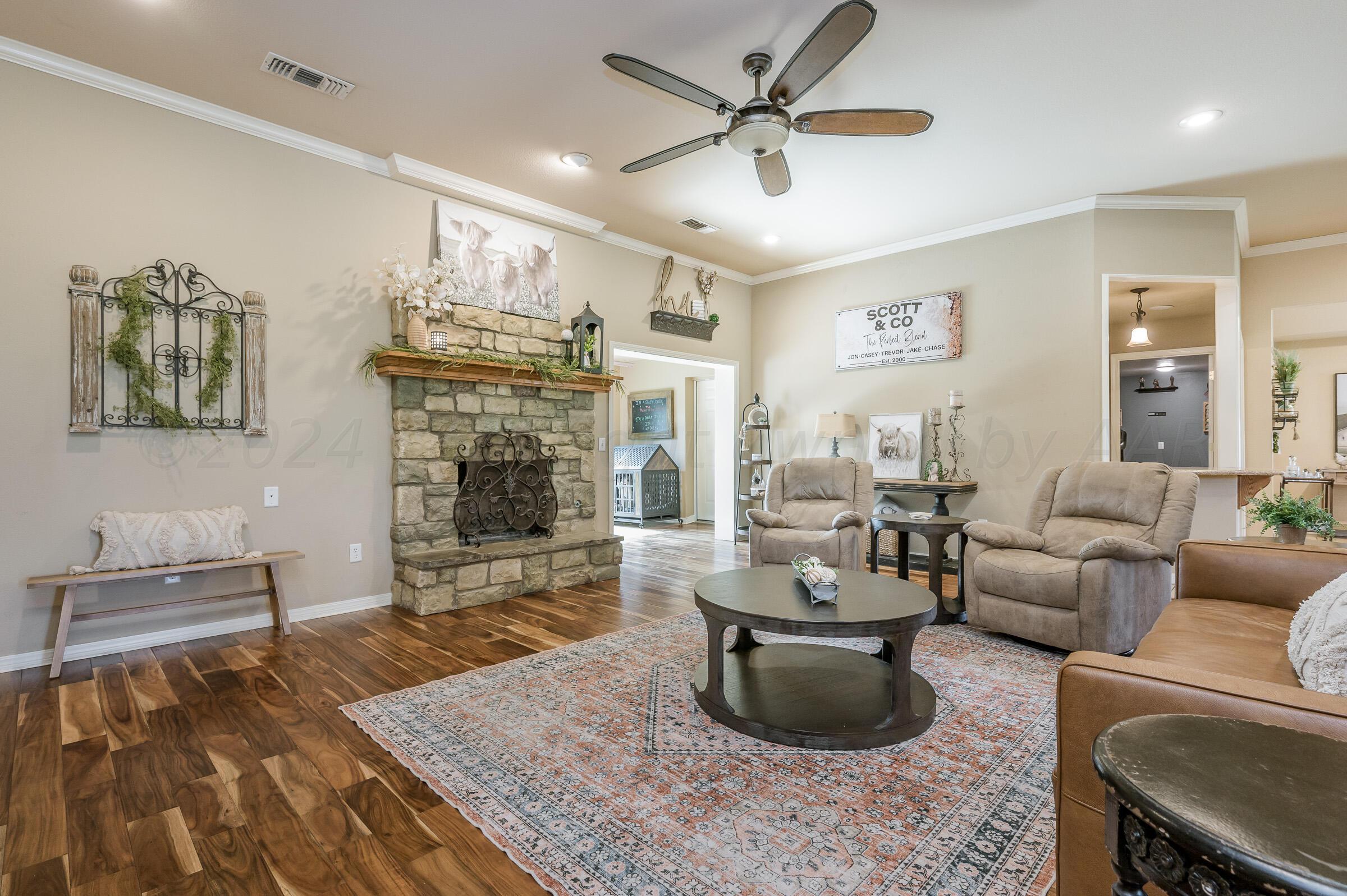 8921 Greyhawk Road Amarillo, TX 79119 - Photo 5 of 56 a living room with fireplace furniture and a chandelier