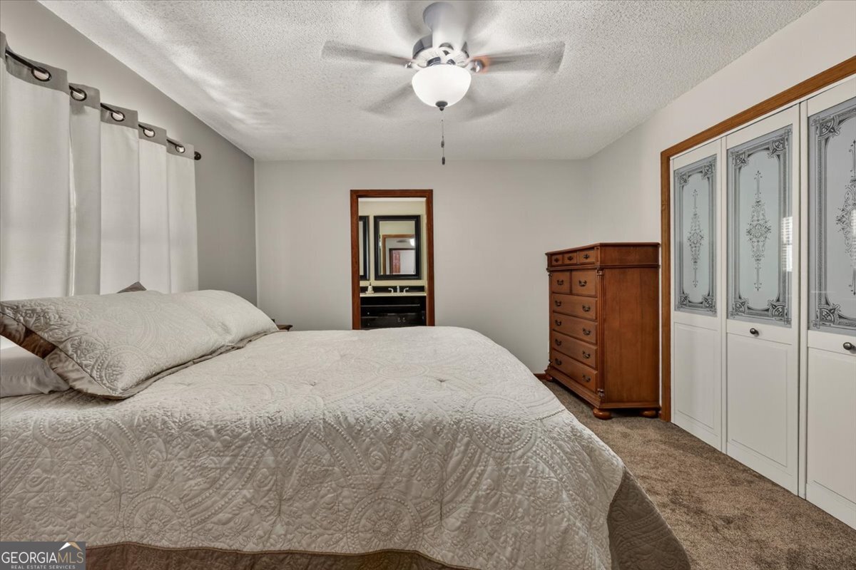348 Craig Road Forsyth, GA 31029 - Photo 15 of 35 a bedroom with a large bed and a chandelier