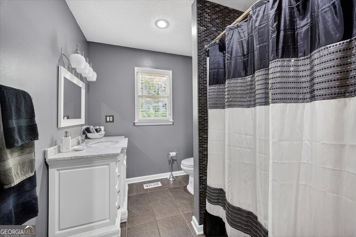 348 Craig Road Forsyth, GA 31029 - Photo 21 of 35 a bathroom with a sink a toilet and shower
