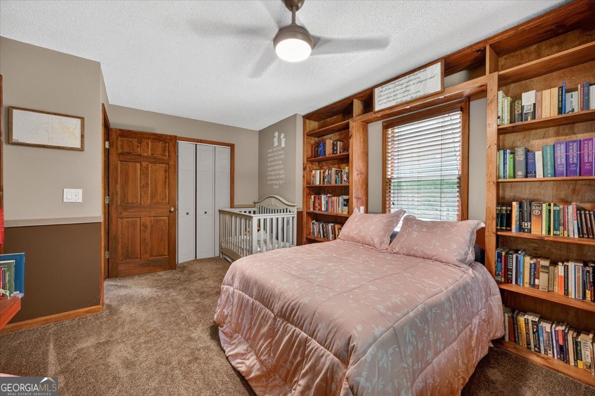 348 Craig Road Forsyth, GA 31029 - Photo 23 of 35 a bedroom with a bed furniture and a book shelf