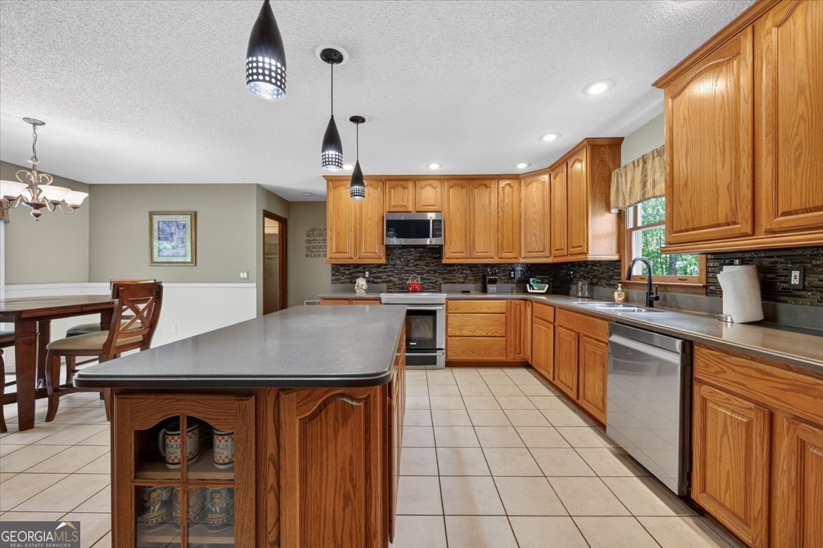 348 Craig Road Forsyth, GA 31029 - Photo 6 of 35 a kitchen with stainless steel appliances granite countertop a stove a sink dishwasher a microwave oven with granite countertops and cabinets