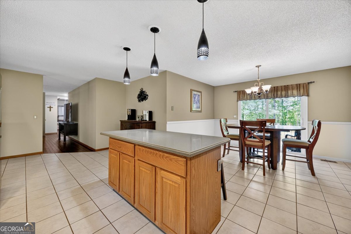 348 Craig Road Forsyth, GA 31029 - Photo 8 of 35 a kitchen with stainless steel appliances granite countertop a stove a sink a dining table and chairs with wooden floor