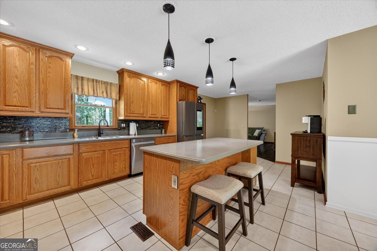 348 Craig Road Forsyth, GA 31029 - Photo 9 of 35 a kitchen with stainless steel appliances granite countertop a stove a sink a refrigerator and chairs