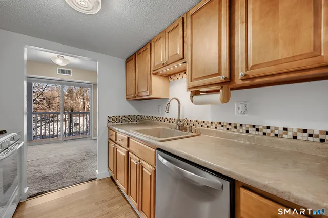 a kitchen with stainless steel appliances granite countertop a sink and a stove