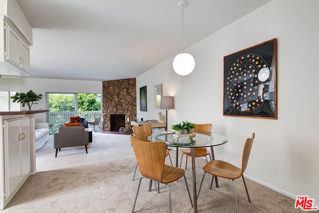 a dining room with furniture a fireplace and a large window