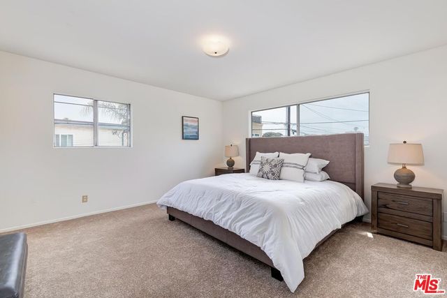 a large bed sitting in a bedroom next to a window