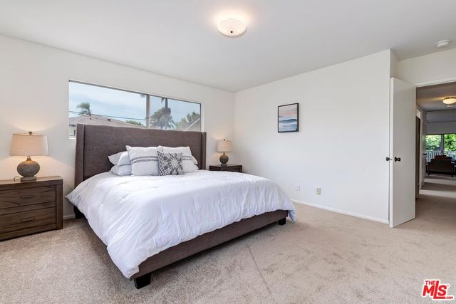 a bedroom with a bed and a painting on the wall