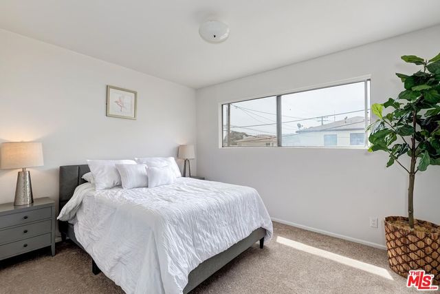 a bedroom with bed and a potted plant