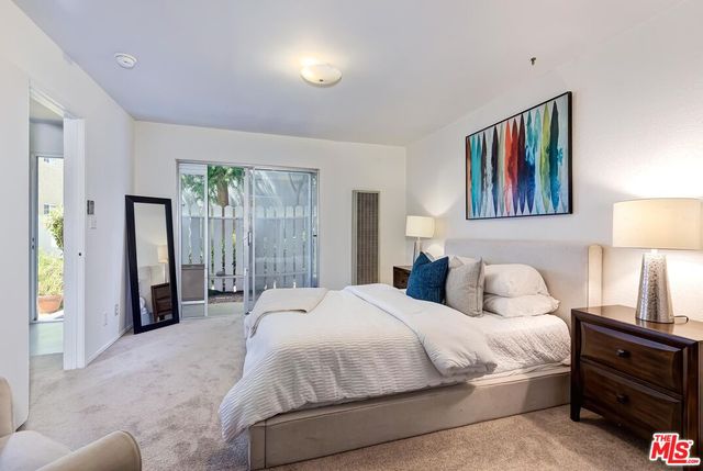 a bedroom with a bed and a painting on the wall