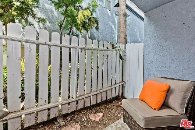 a view of a deck with couches with wooden floor and fence