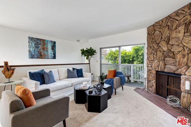 a living room with furniture a fireplace and a window
