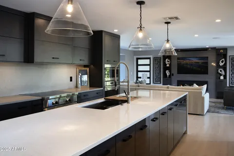 a kitchen with stainless steel appliances a sink a stove and a wooden floors