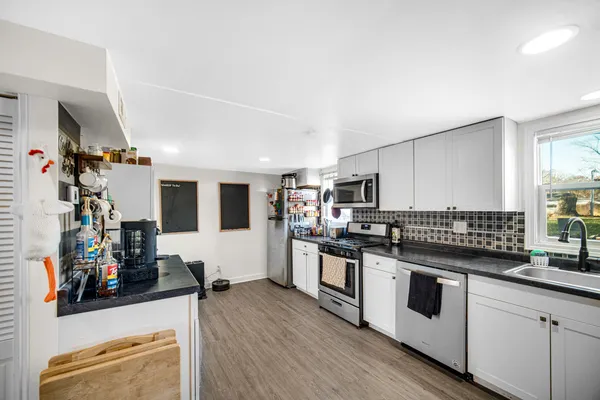 a kitchen with stainless steel appliances granite countertop a stove and cabinets