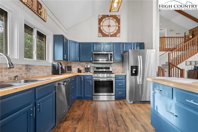 a kitchen with stainless steel appliances granite countertop a stove sink and microwave