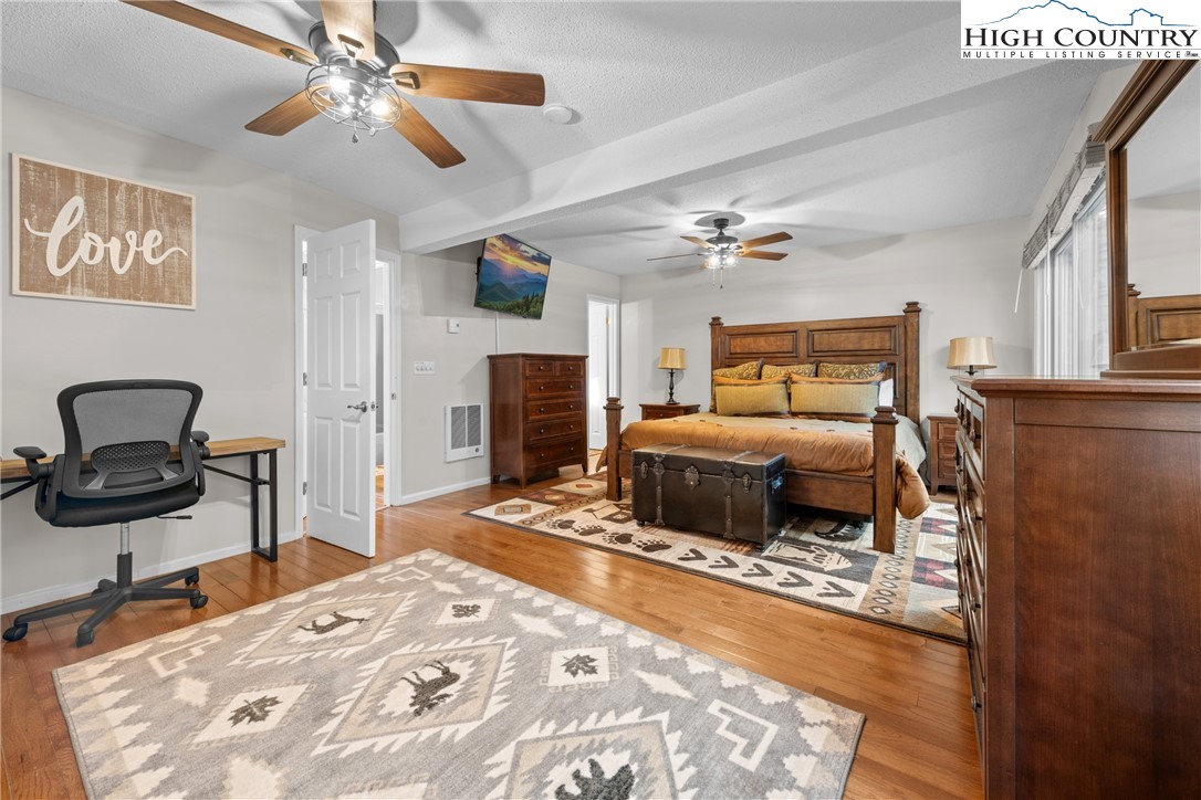 101 Pond Creek Road Banner Elk, NC 28604 - Photo 20 of 35 a bedroom with a bed and a chandelier