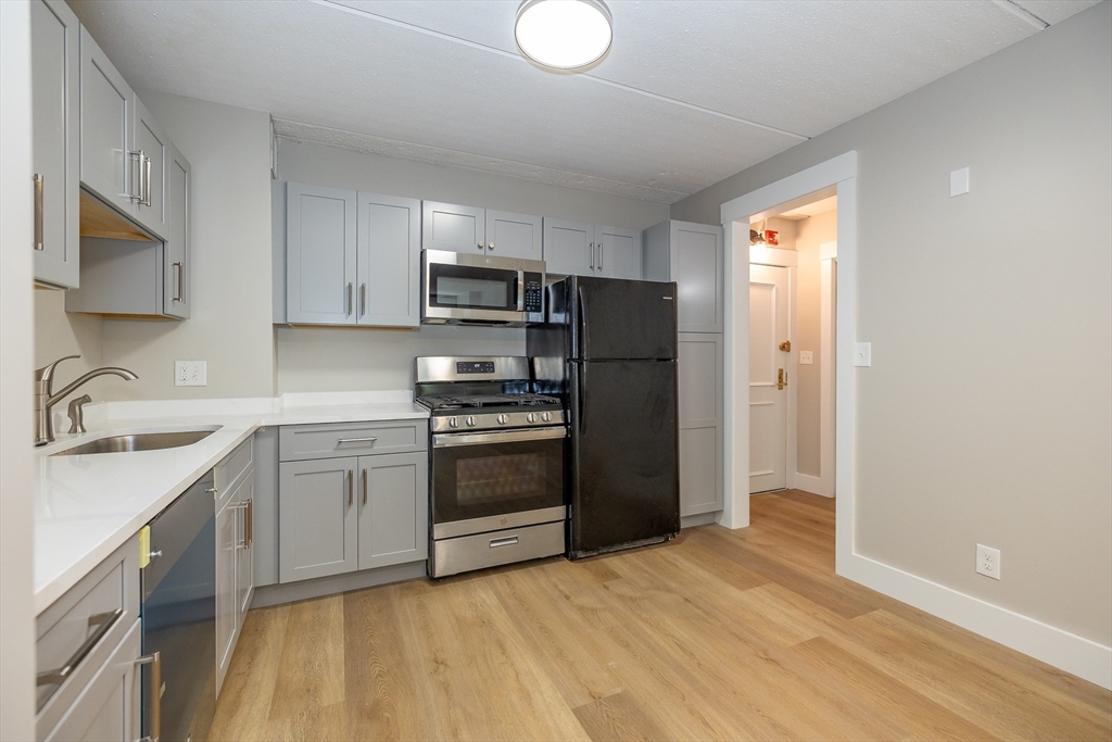 1500 Worcester Road, Unit 217 Framingham, MA 01702 - Photo 13 of 37 a kitchen with a refrigerator sink and stove top oven